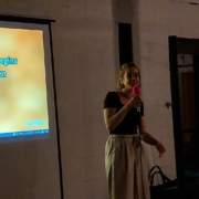 Chorifeen-Karaoke Frau singt Karaoke, im Hintergrund eine Leinwand mit Liedtext.
