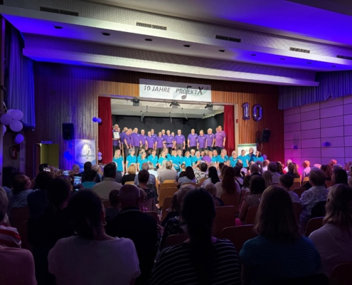 Jubiläum Projekt X 2025. Es wird gemeinsam mit den Chorifeen ein Lied gesungen.